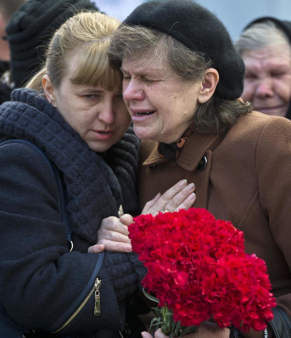 Relatives of Ukrainian soldier Sergey Kokurin, 35, during his funeral in Simferopol, Crimea, Saturday, March 22, 2014. A few hundred mourners gathered to pay their last respects to two men who were shot dead earlier in the week. Ukrainian soldier Sergey Kokurin, 35 and Russian Cossack militiaman Ruslan Kazakov, 34, are the only known victims of what has otherwise been a bloodless takeover of Crimea by Russia.(AP Photo/Vadim Ghirda)