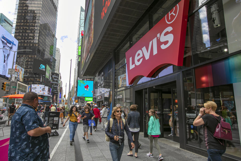 In this June 14, 2019, photo people pass the Levi's store in in New York's Times Square. Levi Strauss & Co.’s new flagship in Manhattan’s Time Square features larger dressing rooms with call buttons and tailors who can add trims and patches to customers’ jeans. (AP Photo/Richard Drew)