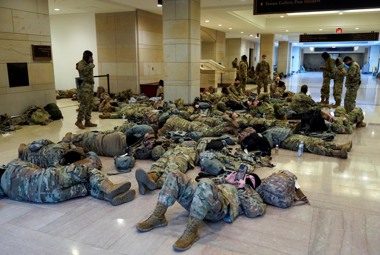 National Guard members sleep in the Capitol Visitor Centre before Democrats begin debating one article of impeachment against Donald Trump (REUTERS)