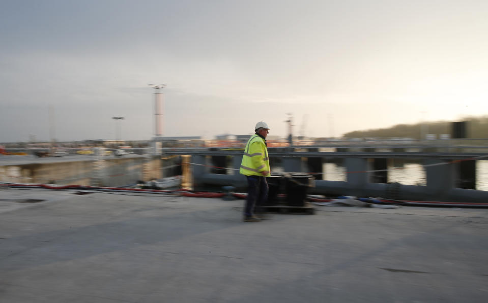 A worker walks on the construction site of the project in Venice, Italy, Friday, Nov. 29, 2019. The system of moveable under water barriers, dubbed Moses, has been beset by corruption, cost overruns and delays. Projected at 1.8 billion euros and to be completed by 2011, the project has cost 5.5 billion euros and won’t be operational before the end of 2021. (AP Photo/Antonio Calanni)