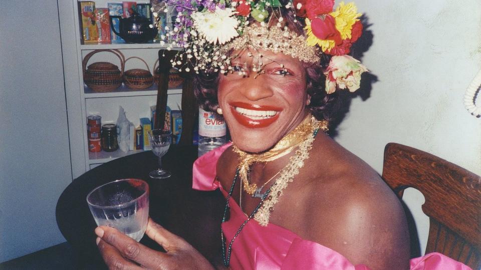 a person wearing a crown and holding a glass of wine