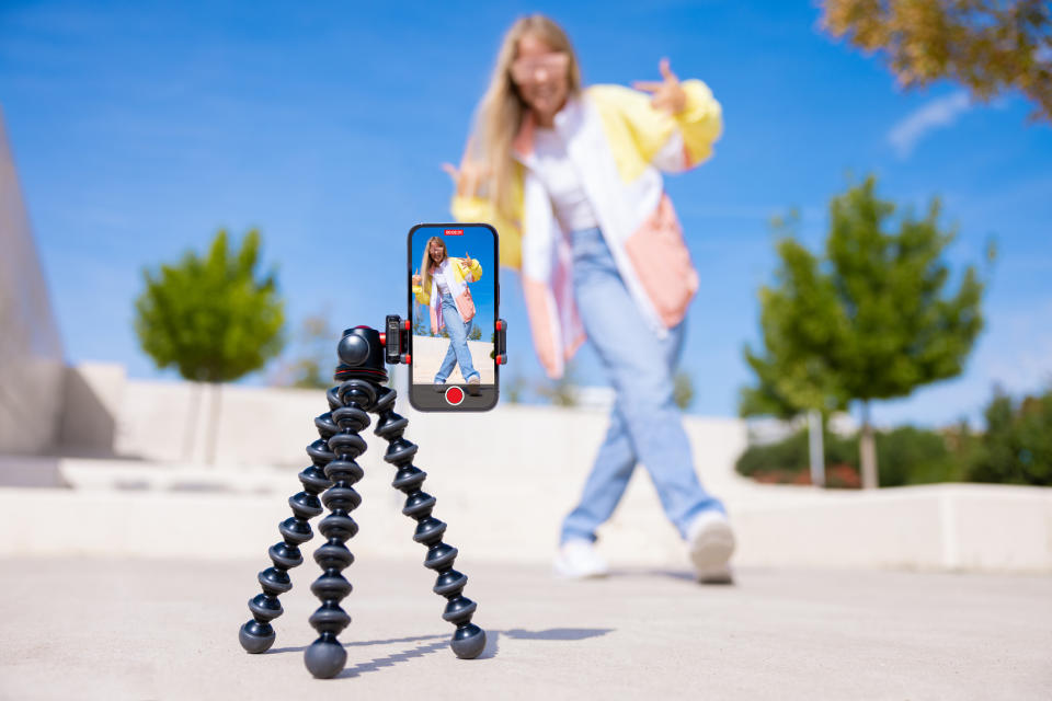 A girl doing a dance while filming it on her phone