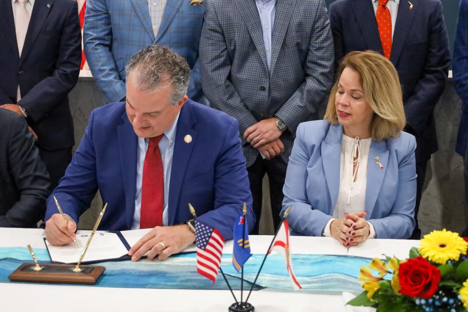 Aruba Prime Minister Evelyn Wever-Croes, at right, watches as Florida Chief Financial Officer Jimmy Patronis signs an agreement Monday for stronger ties between Jacksonville's port and Aruba.