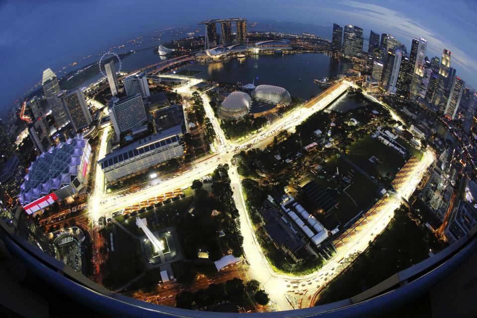 The Marina Bay Formula One street circuit is illuminated at dusk in Singapore, in this September 17, 2013 file photo. Tropical Singapore is now known as a top-class casino-gambling destination, the venue for the world&#39;s first Formula One night race and the bachelor playground of Facebook co-founder Eduardo Saverin. Clean and safe, the prosperous city-state is also a magnet for high-end shoppers and one of the most diverse food capitals in the world. To match Trip Tips story TRAVEL-SINGAPORE/ Picture taken with a fish-eye lens. REUTERS/Edgar Su/Files (SINGAPORE - Tags: SPORT MOTORSPORT TRAVEL)