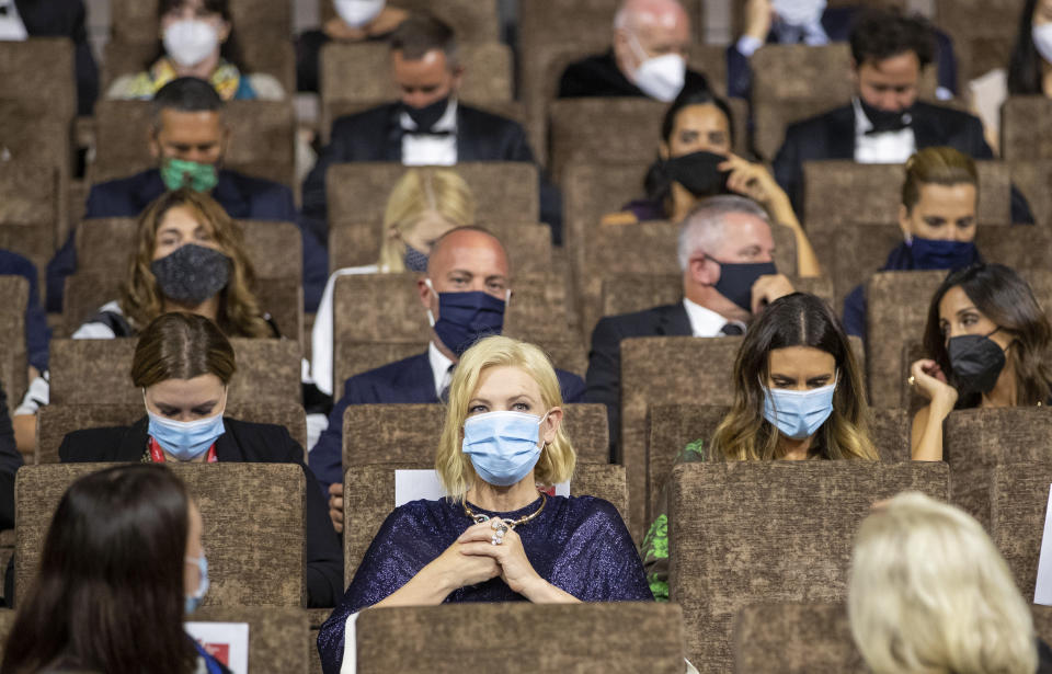 FILE - Jury President Cate Blanchett, center, is seated at the start of the opening ceremony of the 77th edition of the Venice Film Festival at the Venice Lido, Italy, on Sept. 2, 2020. This year, three of the four major fall film festivals, including Venice, are going forward despite the pandemic. Those in Venice acknowledge it hasn’t been anywhere near the same. Masked moviegoers in set-apart seats. A barrier walls off the red carpet to discourage crowds of onlookers. Greetings are kiss-less. A little bit of the romance of movies has gone out. (AP Photo/Domenico Stinellis, File)