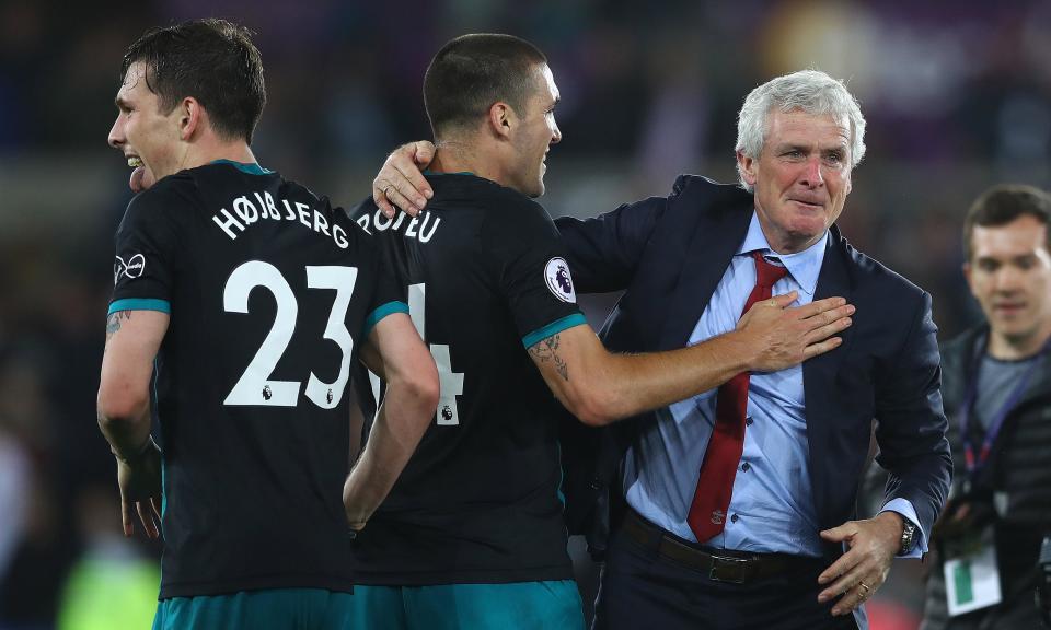 Marching on: Mark Hughes celebrates with his players after Southampton’s victory at Swansea