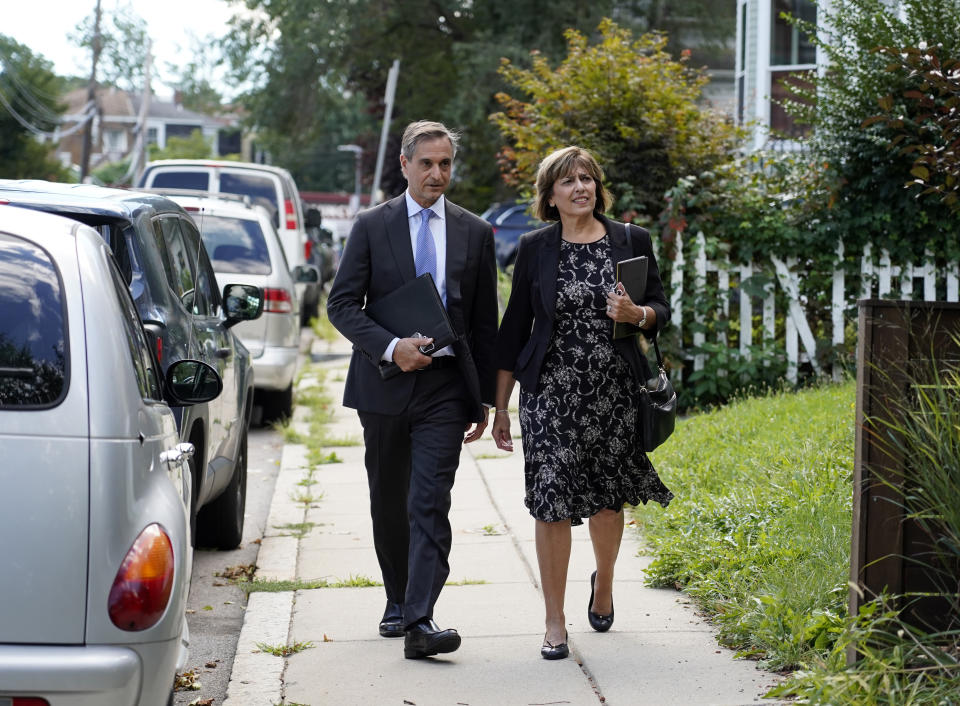 Dan Sideris and his wife, Carrie Sideris, of Newton, Mass., walk along a sidewalk as they return to door-to-door visits as Jehovah's Witnesses, Thursday, Sept. 1, 2022, in Boston. From coast to coast, members of the Christian denomination fanned out in cities and towns Thursday to share literature and converse about God for the first time since March 2020. (AP Photo/Mary Schwalm)