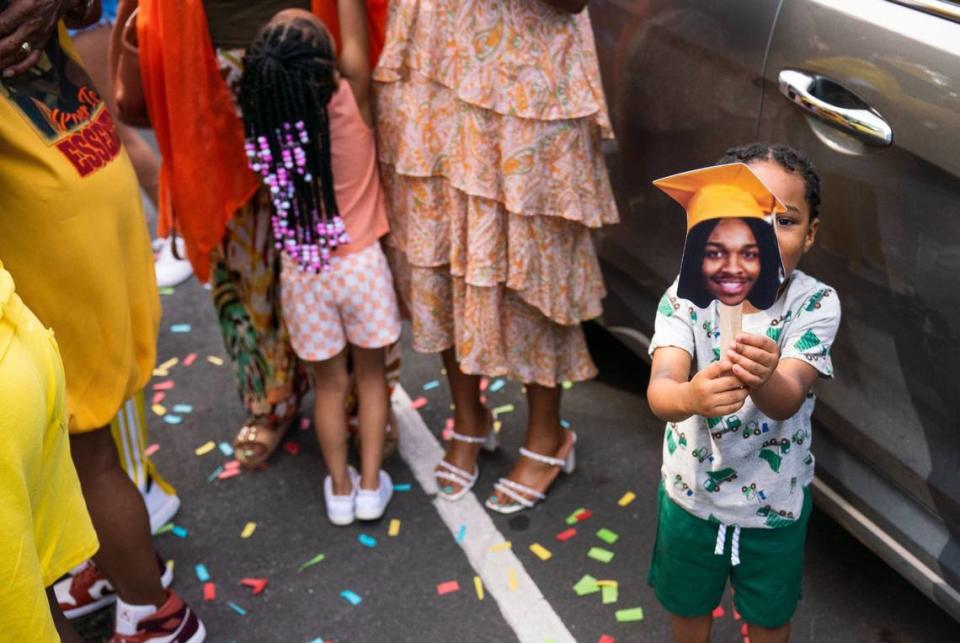 Jonas Campbell holding up a picture of his newly graduated uncle Joe Houston after graduation, at the Bojangles Coliseum in Charlotte on Monday, June 10, 2024.