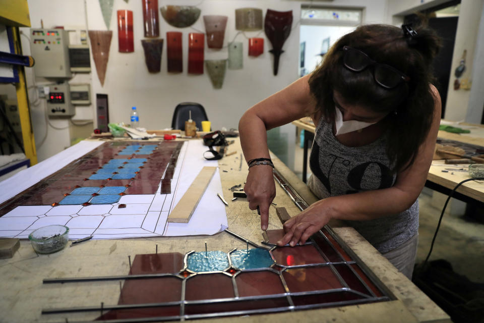 A stain glass artist works to recreate one of the stained-glass windows that were the trademark of Beirut’s Sursock Museum, shattered in last year’s port explosion, at the Maya Hussaini workshop, in Beirut, Lebanon, Monday, June 28, 2021. Lebanon's only modern art museum, the Sursock, was the beating heart of Beirut's arts community, and some hope that reopening it will be a first step in the harder task of rebuilding the city's once thriving arts scene. (AP Photo/Hussein Malla)