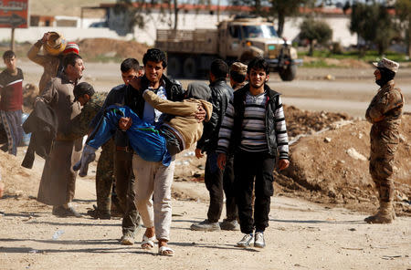 Displaced people are checked by Iraqi forces as Iraqi forces battle with Islamic State militants, in western Mosul, Iraq March 25, 2017. REUTERS/Suhaib Salem