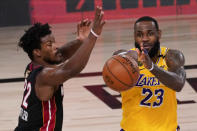 Los Angeles Lakers forward LeBron James, right, passes around Miami Heat forward Jimmy Butler during the second half in Game 4 of basketball's NBA Finals Tuesday, Oct. 6, 2020, in Lake Buena Vista, Fla. (AP Photo/John Raoux)