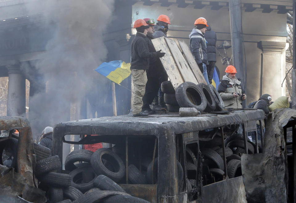 Protesters guard the barricades in front of riot police in Kiev, Ukraine, Monday, Jan. 27, 2014. Ukraine's justice minister is threatening to call for a state of emergency unless protesters leave her ministry building, which they occupied during the night. The seizure of the building early Monday underlined how anti-government demonstrators are increasingly willing to take dramatic action as they push for the president's resignation and other concessions. Protesters now occupy four sizable buildings in central Kiev, including the city hall. (AP Photo/Efrem Lukatsky)