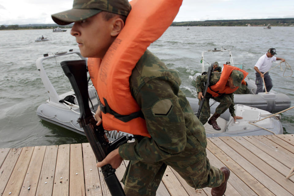 Brazilian marines take part in practice drill in preparation for World Cup security at Paranoa lake in Brasilia, Brazil, Thursday, Feb. 20, 2014. Brazil’s Navy said that the operations being carried out this week in preparation for the 2014 FIFA World Cup are the largest exercises in its history. FIFA director of security Ralf Mutschke has said that FIFA is satisfied with the level of security that will be provided by Brazilian authorities, and guarantees that football's governing body "is highly committed to ensuring the safety and security for fans, players and any other stakeholder involved in our event." (AP Photo/Eraldo Peres)