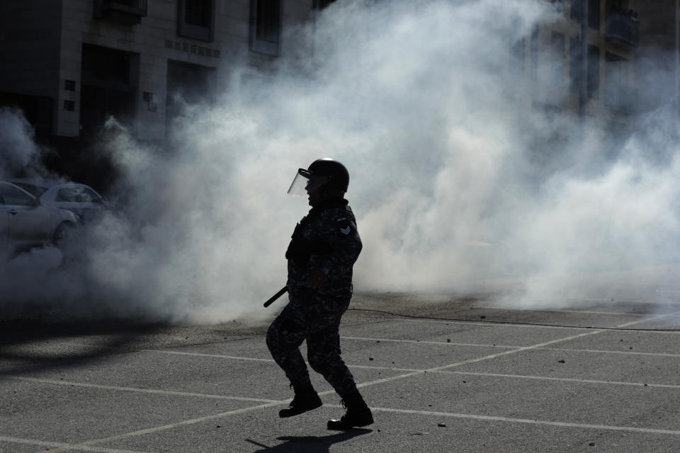 Riot police fire tear gas against anti-government demonstrators during a protest in downtown Beirut, Lebanon, Monday, Jan. 27, 2020. Lebanese security forces scuffled Monday with protesters near the parliament building in downtown Beirut where lawmakers are scheduled to begin a two-day discussion and later approval of the budget amid a crippling financial crisis. (AP Photo/Hassan Ammar)