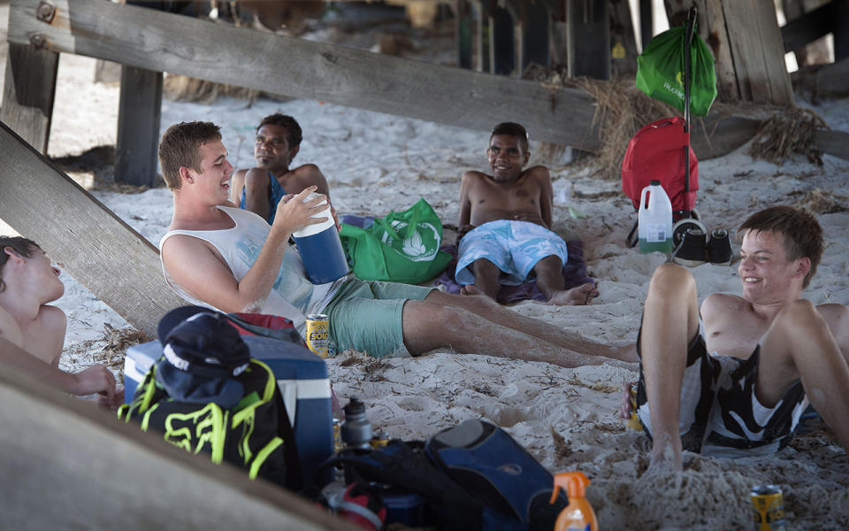 A group of mates cool down under the jetty at Semaphore beach in Adelaide. 