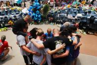 People visit a growing memorial at the Dallas police department's headquarters on July 9, 2016 in Texas