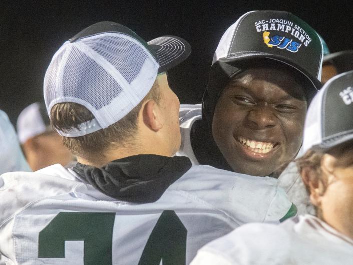 Manteca&#39;s Cris Ray, right, hugs teammate Marcus Brennan after winning the Sac-Joaquin Section Division III championship over Oakdale at St. Mary&#39;s High School in Stockton. Manteca won 35-28.