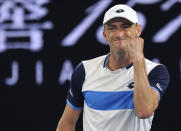 Australia's John Millman celebrates a point win over Switzerland's Roger Federer during their third round match at the Australian Open tennis championship in Melbourne, Australia, Friday, Jan. 24, 2020. (AP Photo/Lee Jin-man)