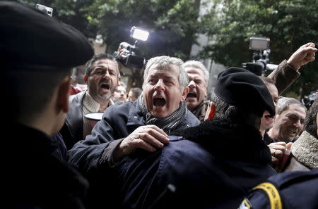 Workers at state hospitals shout slogans next to a police cordon during a demonstration against planned pension reforms outside the Finance ministry in Athens, Greece, January 26, 2016. REUTERS/Alkis Konstantinidis