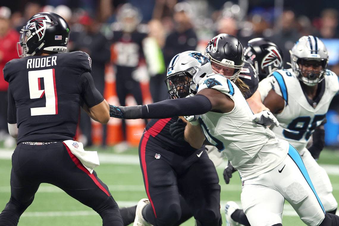 Carolina Panthers linebacker Brian Burns, right, reaches out to strip Atlanta Falcons quarterback Desmond Ridder, left, of the ball during first-quarter action at Mercedes-Benz Stadium in Atlanta, GA on Sunday, September 10, 2023. 