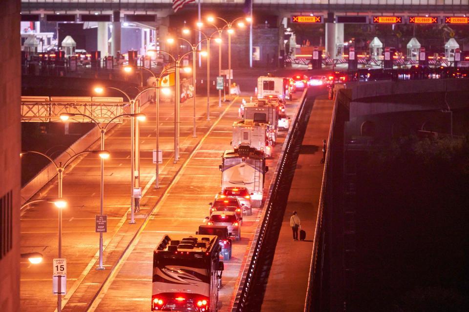 TOPSHOT - A pedestrian walks past a line of Canadian travelers in their passenger cars or motor homes on the Rainbow Bridge between Niagara Falls, Ontario and Niagara Falls, New York in the early hours of November 8, 2021. - The United States reopens its land and air borders Monday November 8 to foreign visitors fully vaccinated against Covid-19, ending 20 months of restrictions on travel from around the globe that separated families, hobbled tourism and strained diplomatic ties.
The ban, imposed by former president Donald Trump in early 2020 and upheld by his successor Joe Biden, has been widely criticized and become emblematic of the upheavals caused by the pandemic. 
The restrictions were particularly unpopular in Europe and US neighbors Canada and Mexico. (Photo by Geoff Robins / AFP) (Photo by GEOFF ROBINS/AFP via Getty Images)