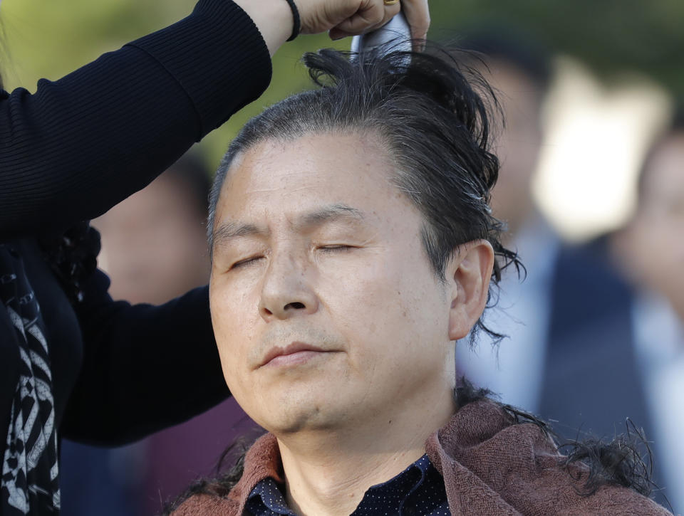 Hwang Kyo-ahn, the main opposition Liberty Korea Party chairman, has his head shaved in Seoul, South Korea, Monday, Sept. 16, 2019. The leader of South Korea's biggest opposition party has become the latest politician to shave their heads to protest President Moon Jae-in's appointment of a key political ally as justice minister despite allegations of academic fraud and financial crimes surrounding his family. (AP Photo/Lee Jin-man)