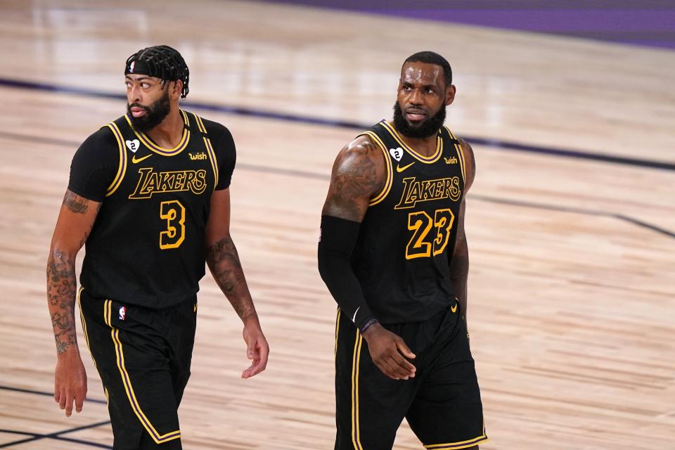 Los Angeles Lakers' Anthony Davis (3) and LeBron James (23) walk up court during the first half of Game 2 of basketball's NBA Finals against the Miami Heat on Friday, Oct. 2, 2020, in Lake Buena Vista, Fla. (AP Photo/Mark J. Terrill)