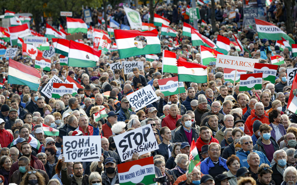 People hold banners that read "Never Again" during a march marking the 65th anniversary of the 1956 Hungarian revolution, in Budapest, Hungary, Saturday, Oct. 23, 2021. Thousands of supporters of Prime Minister Viktor Orban, who is expected to deliver a speech marking the 65th anniversary of the 1956 Hungarian revolution, march in Budapest, Hungary to demonstrate loyalty to his right-wing government. (AP Photo/Laszlo Balogh)