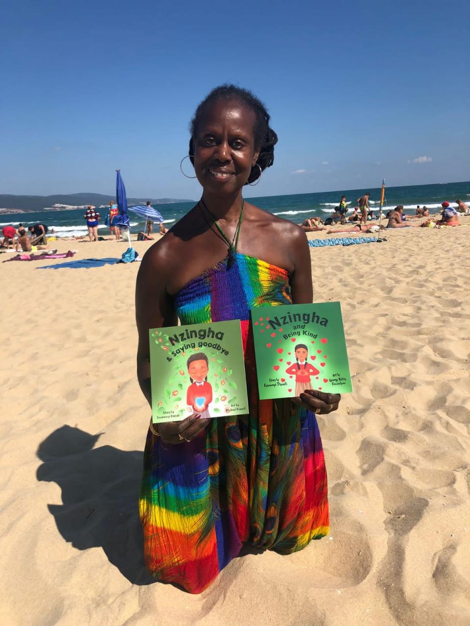 Woman looking at the camera and holding books in her hands