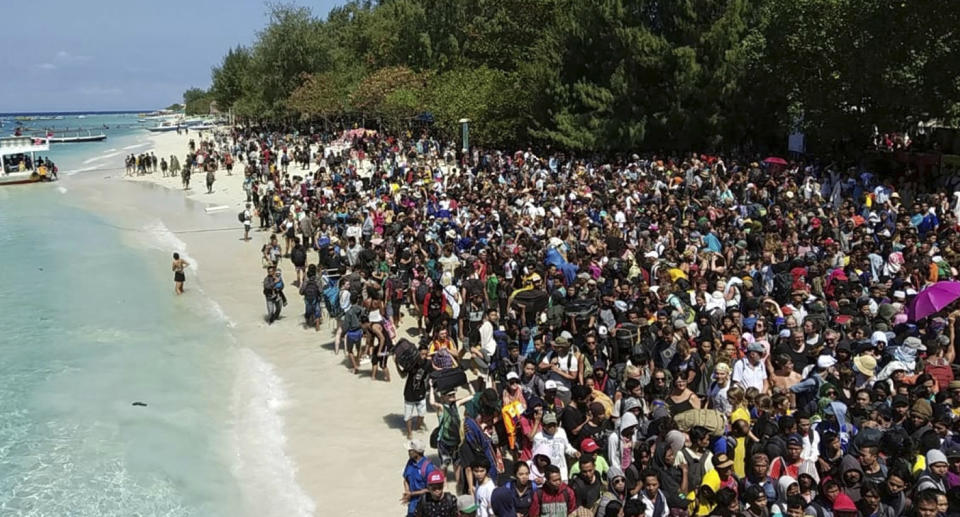 Tourists line up in droves to evacuate the neighbouring Gili Trawangan Island on Monday. Source: AAP