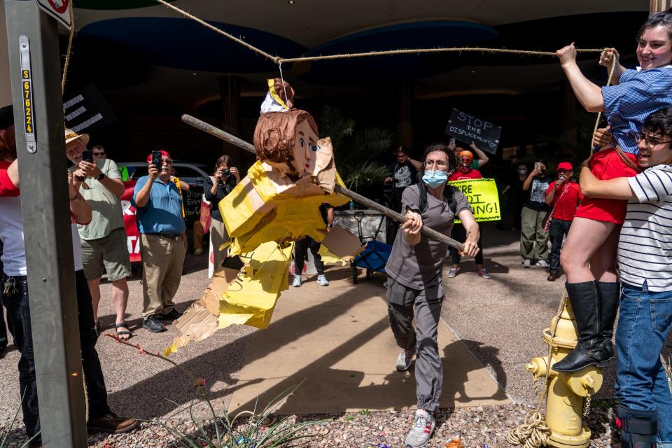 Maggie Johnson hits a piñata of Phoenix Mayor Kate Gallego during a protest outside the Sheraton Phoenix Downtown hotel, ahead of Gallego's State of the City address, in Phoenix on April 12, 2023.