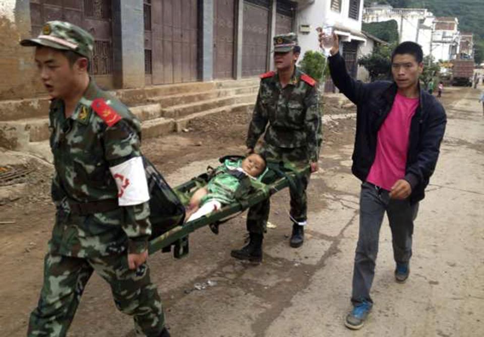 Paramilitary policemen carry an injured child on a stretcher as they carry out rescue operations after an earthquake hit Longtoushan township of Ludian county, Yunnan province August 3, 2014. A magnitude 6.3 earthquake struck southwestern China on Sunday, killing at least 26 people in a remote mountainous area of Yunnan province, causing some buildings to collapse including a school. REUTERS/Stringer (CHINA - Tags: DISASTER ENVIRONMENT) CHINA OUT. NO COMMERCIAL OR EDITORIAL SALES IN CHINA