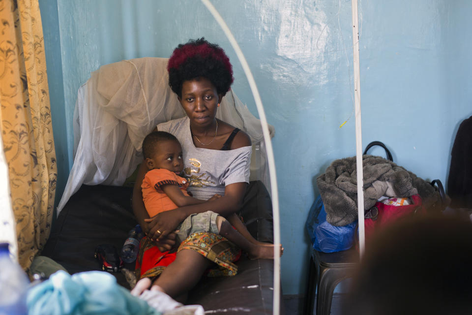 Ado Ntanga, 23, holds her son, Adrielle Nyembwe, 3, who was admitted to the Medicare Policlinic with Sickle Cell Anemia in Lubumbashi, Democratic Republic of the Congo on Wednesday, Aug. 15, 2018. They have both been detained for over a month, unable to pay the $850 medical bill for Adrielle. (AP Photo/Jerome Delay)