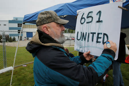 Greg Litsios, a fabrication mechanic with 28 years of experience, re-letters a sign as locked-out members of the Local 651 International Brotherhood of Boilermakers union stand outside Westinghouse Electric's manufacturing facility in Newington, New Hampshire, U.S., May 22, 2017. REUTERS/Brian Snyder