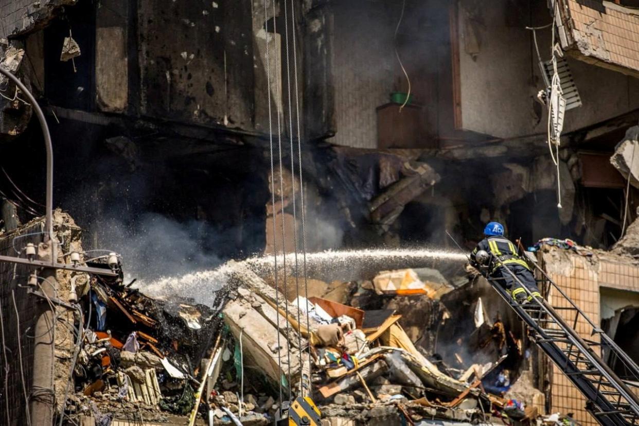 A firefighter works at a site of an apartment building heavily damaged by a Russian missile strike in Kryvyi Rih (via REUTERS)