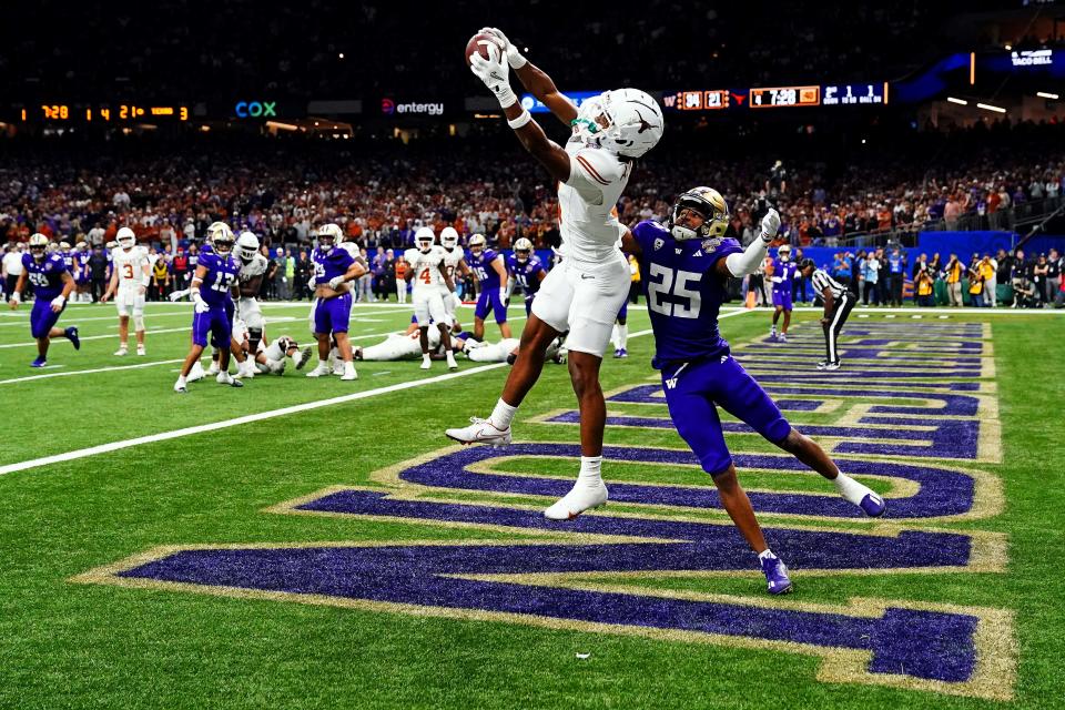 Jan 1, 2024; New Orleans, LA, USA; Texas Longhorns wide receiver Adonai Mitchell (5) catches a touchdown pass against Washington Huskies running back Ryder Bumgarner (25) during the fourth quarter in the 2024 Sugar Bowl college football playoff semifinal game at Caesars Superdome. Mandatory Credit: John David Mercer-USA TODAY Sports