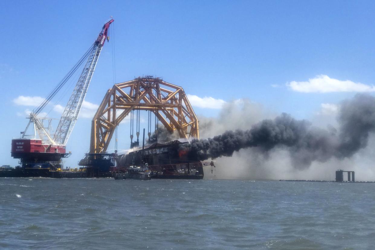 In this photo provided by conservation group Altamaha Riverkeeper, smoke pours from the remnants of the capsized cargo ship Golden Ray on Friday off St. Simons Island, Ga.
