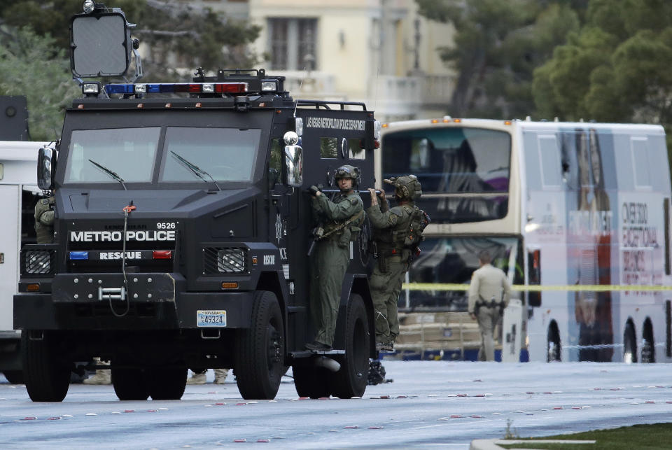 Las Vegas SWAT officers leave the scene of a stand-off in a bus along Las Vegas Boulevard, Saturday, March 25, 2017, in Las Vegas. Las Vegas police said the gunman in a fatal shooting on the Strip who barricaded himself inside a public bus has surrendered peacefully after shutting down the busy tourism corridor for hours. (AP Photo/John Locher)