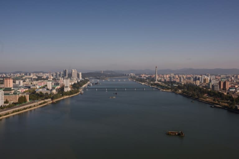 The Pyongyang city skyline shows the landmark Juche tower (centre R) and the Kim Il-Sung stadium (top C) along the Taedong river