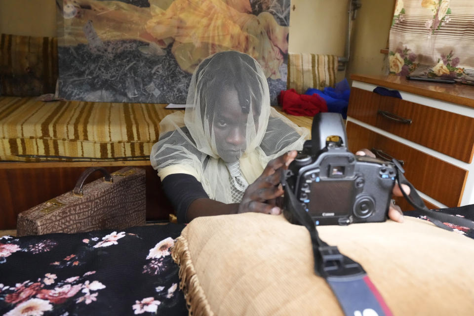 Zimbabwean artist Nothando Chiwanga works on her latest piece, covering her face with a transparent white veil and moving a camera back and forth to catch the right angles of herself, in Harare, Friday, March 24, 2023. Chiwanga is one of 21 female artists whose works have been on show at the southern African country's national gallery since International Women's Day on March 8. The exhibition is titled "We Should All Be Human" and is a homage to women's ambitions and their victories, art curator Fadzai Muchemwa said. (AP Photo/Tsvangirayi Mukwazhi)