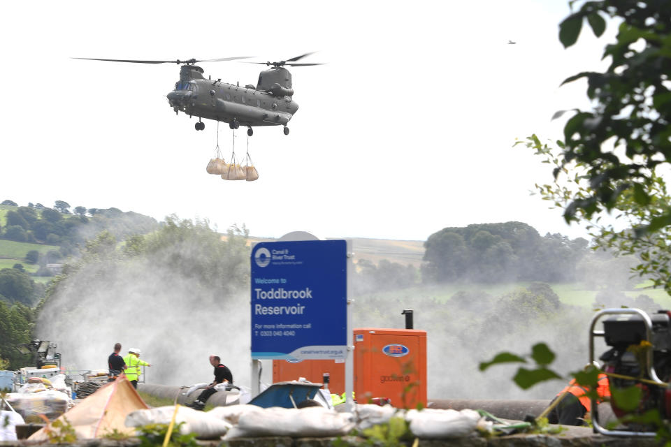 A Royal Air Force Chinook transports sandbags as work continues to shore up the dam at Toddbrook Reservoir near the village of Whaley Bridge, Derbyshire, after it was damaged in heavy rainfall.