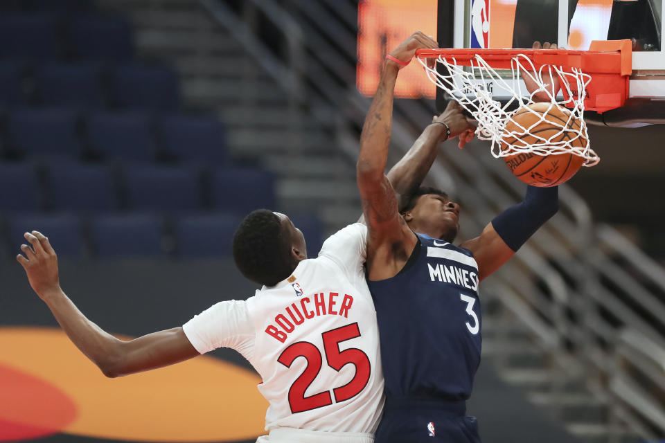 Minnesota Timberwolves' Jaden McDaniels (3) dunks past Toronto Raptors' Chris Boucher during the first half of an NBA basketball game Sunday, Feb. 14, 2021, in Tampa, Fla. (AP Photo/Mike Carlson)