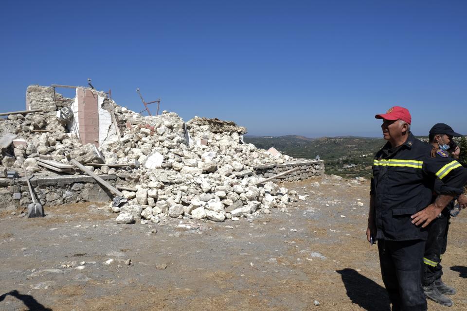 Firefighters stand next to a demolished Greek Orthodox church of Profitis Ilias after a strong earthquake in Arkalochori village on the southern island of Crete, Greece, Monday, Sept. 27, 2021. A strong earthquake with a preliminary magnitude of 5.8 has struck the southern Greek island of Crete, and Greek authorities say one person has been killed and several more have been injured. (AP Photo/Harry Nikos)