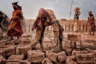 <p>Men and women work alongside one another in West Bengal, India, lifting heavy bricks for construction. (Shibasish Saha) </p>