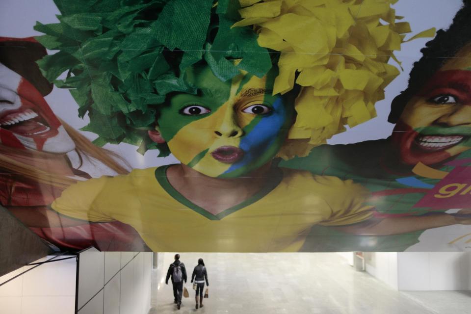 Passengers walk near advertising panels depicting the World Cup in Brasilia International airport. (Ueslei Marcelino/Reuters)