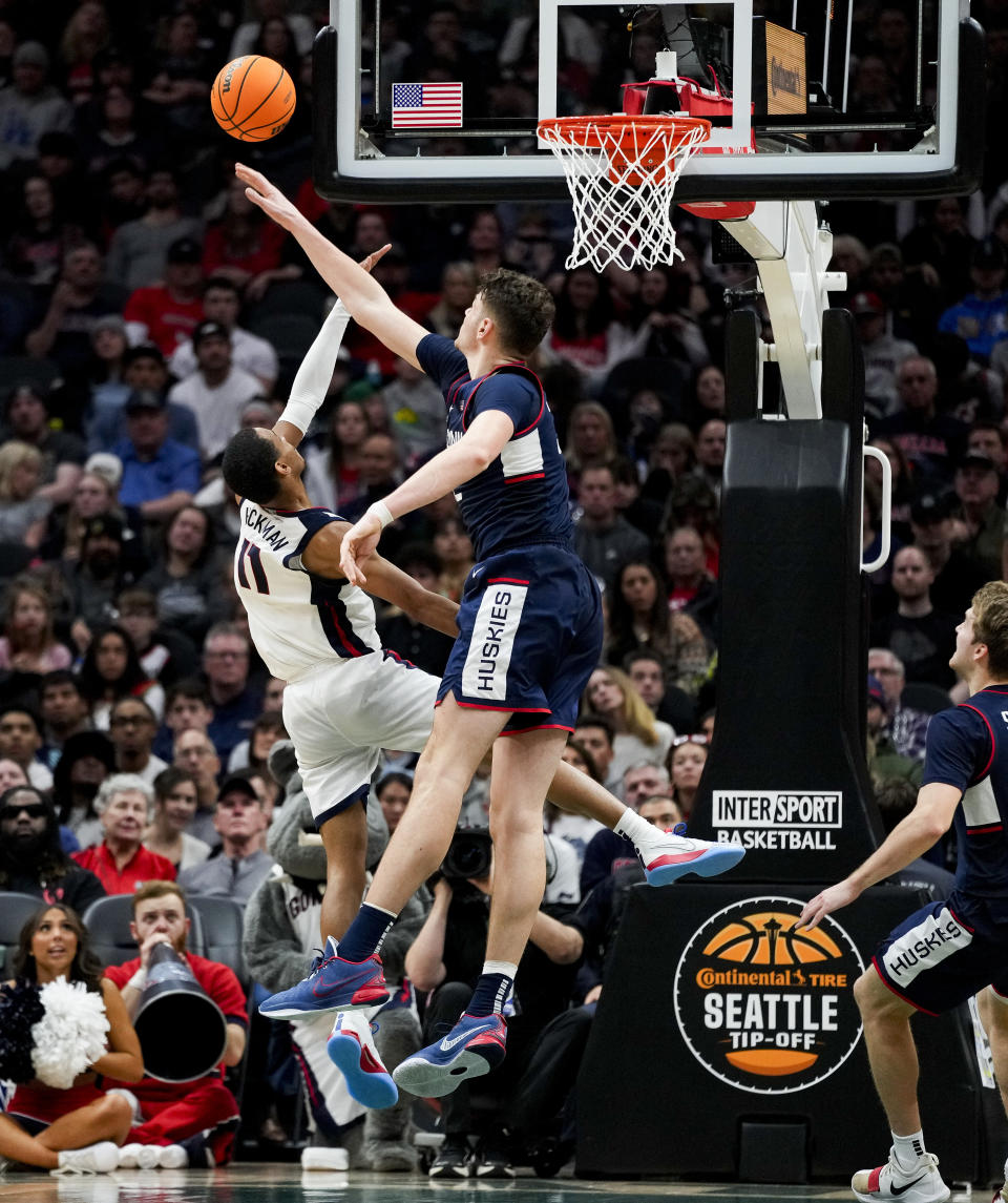 UConn center Donovan Clingan, center, swats the ball away from Gonzaga guard Nolan Hickman (11) during the second half of an NCAA college basketball game Friday, Dec. 15, 2023, in Seattle. (AP Photo/Lindsey Wasson)