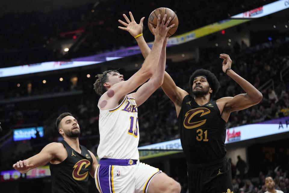 Lakers guard Austin Reaves shoots between Cavaliers guard Max Strus and center Jarrett Allen