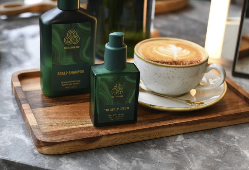 a cup of coffee and a bottle of tea on a wooden table