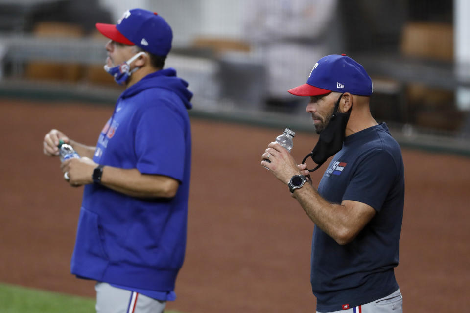 Texas Rangers manager Chris Woodward, right, and pitching coach Julio Rangel, left, watch the team during an intrasquad game during a baseball practice at Globe Life Field in Arlington, Texas, Monday, July 6, 2020. (AP Photo/Tony Gutierrez)