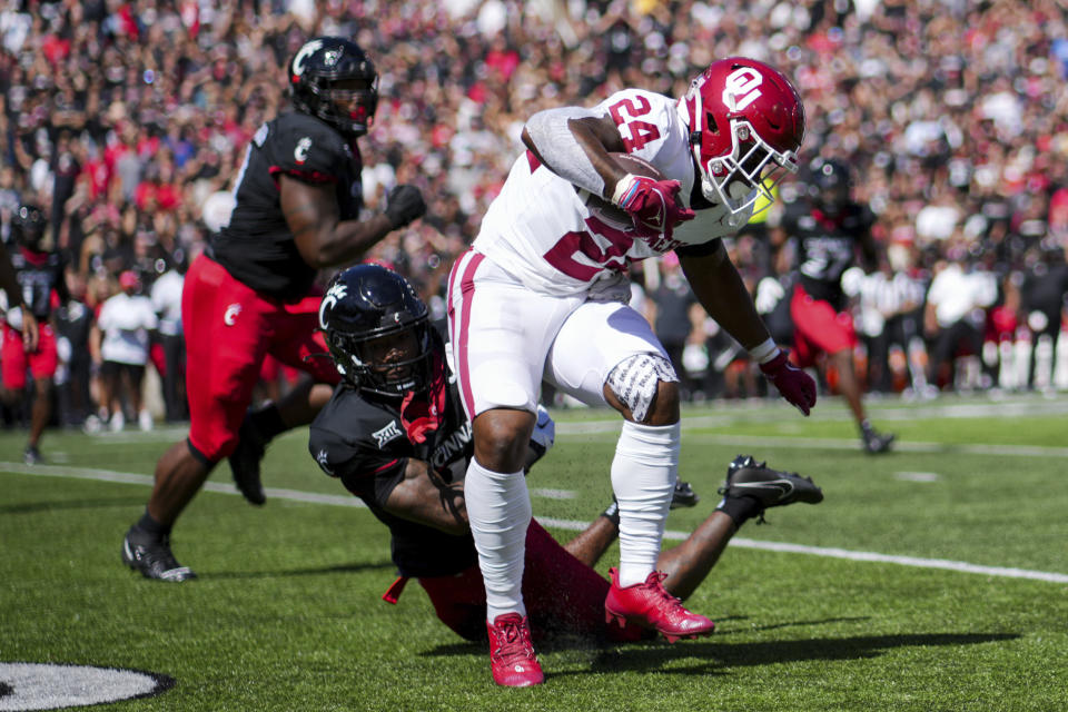 Oklahoma running back Marcus Major (24) carries the ball as he breaks a tackle against Cincinnati cornerback Justin Harris (12) during the first half of an NCAA college football game, Saturday, Sept. 16, 2023, in Cincinnati. (AP Photo/Aaron Doster)